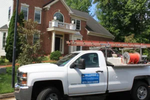 AllPro PowerWashing truck with pressure washing equipment parked outside a brick colonial home