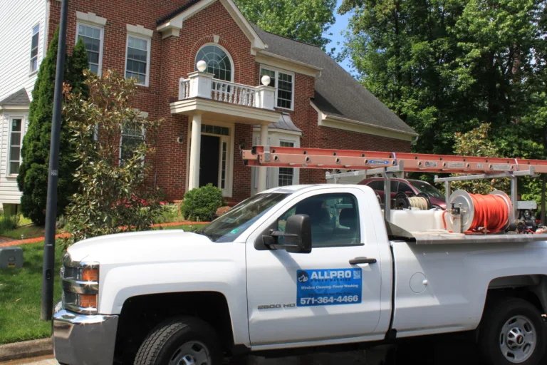 AllPro PowerWashing truck with pressure washing equipment parked outside a brick colonial home