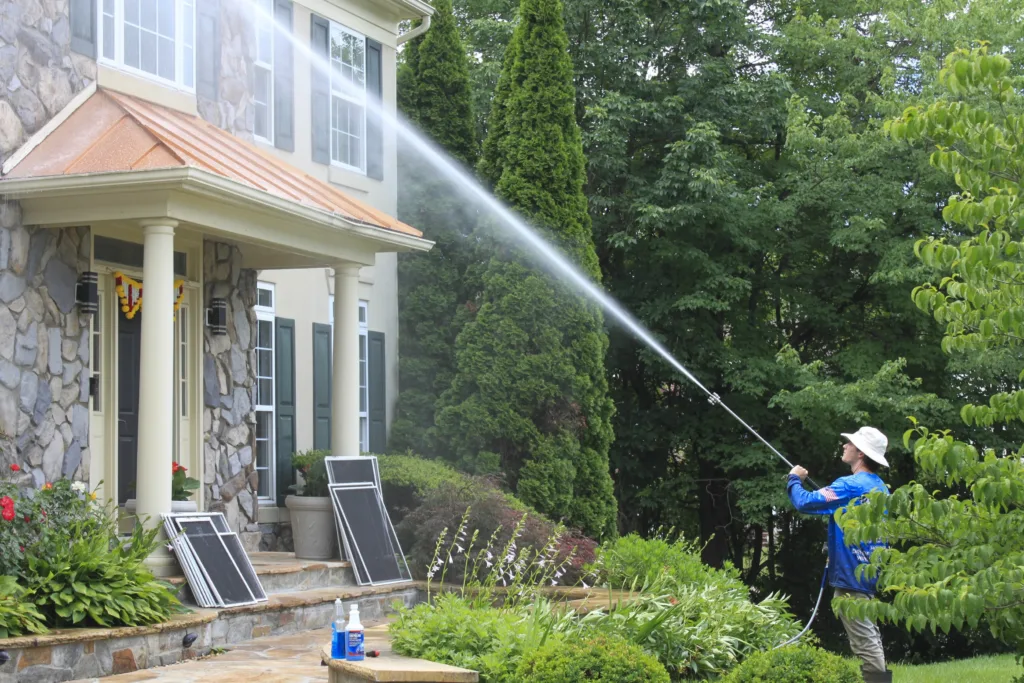 AllPro technician soft washing the stone front and portico of a colonial home