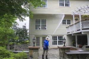 AllPro technician washing the back of a three-story home with a raised deck