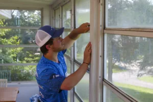 AllPro technician hand-cleaning the windows of a screened porch